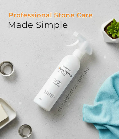 White bottle with 'stonedoctor.com.au' branding on a gray surface with cleaning tools and a plant.