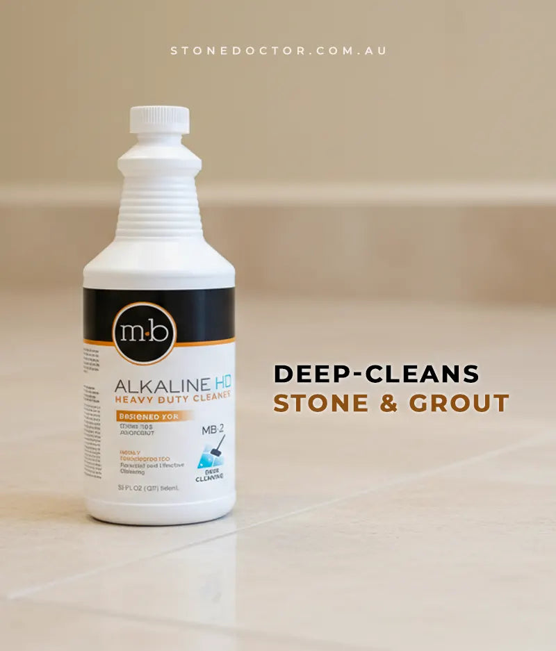 Bottle of m-b Alkaline HD Heavy Duty Cleaner on a tiled floor with text 'DEEP-CLEANS STONE & GROUT'.